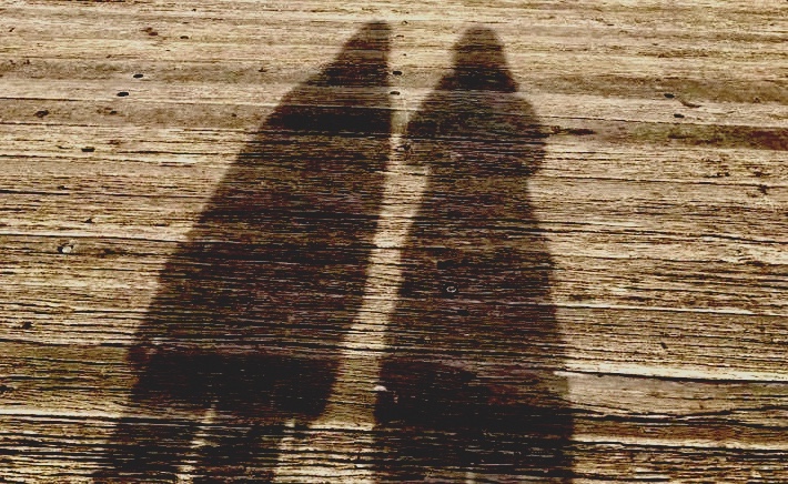 The shadows of two women on timber decking