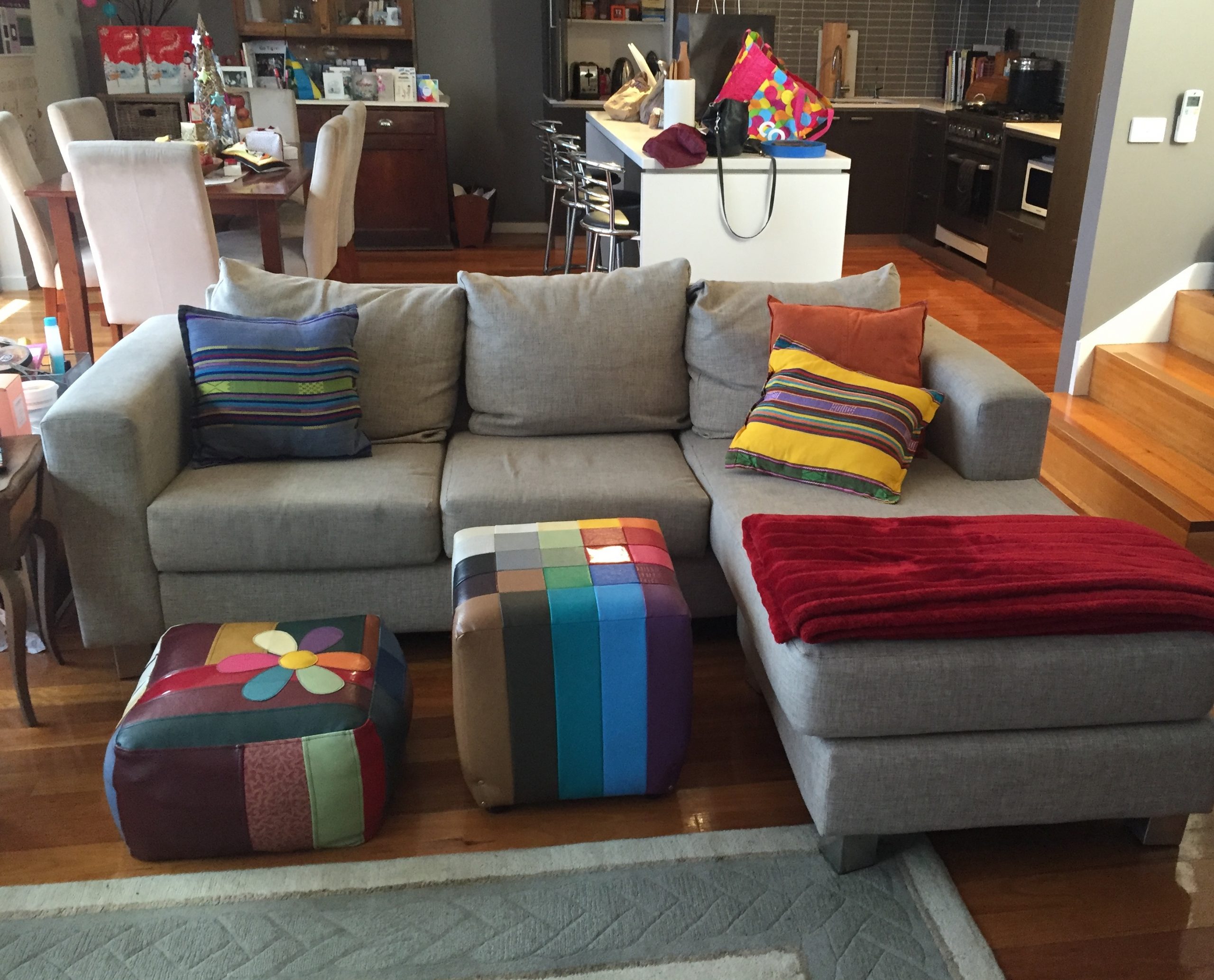A living area with a couch covered in brightly coloured cushions