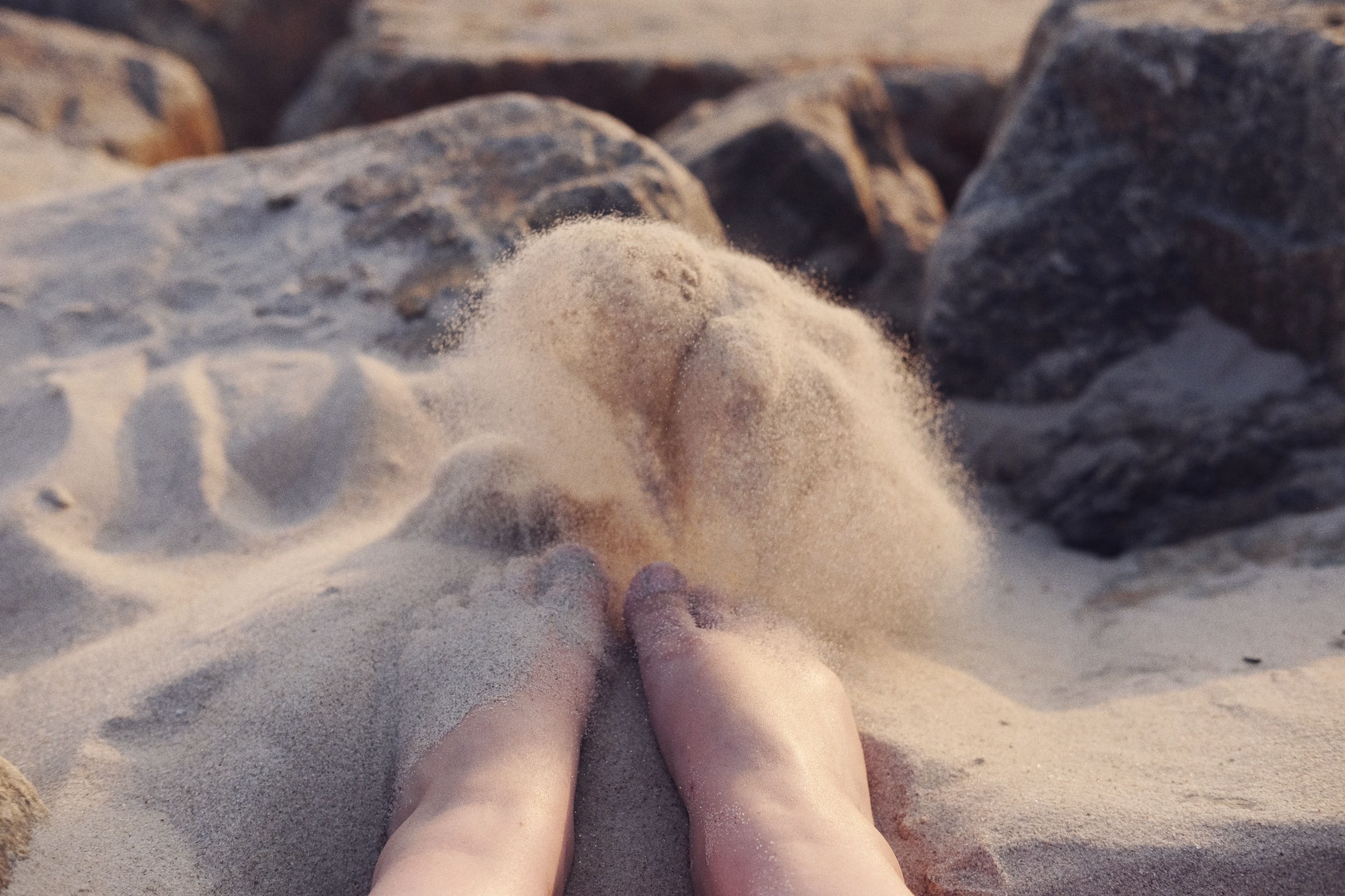 Bare feet half buried in fine sand